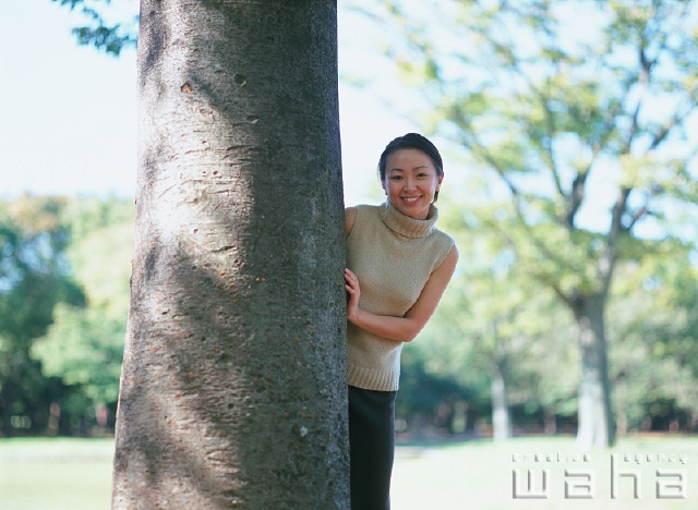 イラスト＆写真のストックフォトwaha（ワーハ）　人物、日本人、女性、20代、30代、公園、屋外、正面、上半身、逆光、ポートレート、散歩、遊ぶ、草原、隠れる、かくれんぼ、遊ぶ、あそぶ、あそび、遊ぶ、遊び　p2-0315a