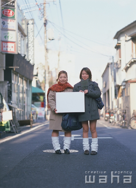 イラスト＆写真のストックフォトwaha（ワーハ）　人物、日本人、メッセージボード、高校生、学生、屋外、正面、全身、ポートレート、2人、友達、住宅街、ピーコート、ルーズソックス、マフラー、空　p2-1918a