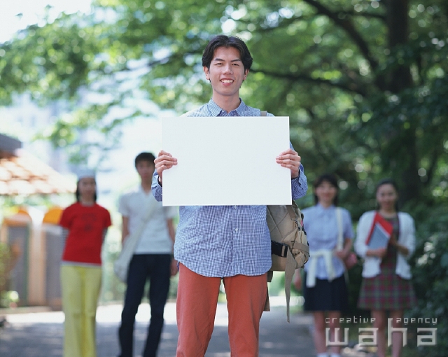 イラスト＆写真のストックフォトwaha（ワーハ）　人物、日本人、メッセージボード、大学生、学生、街、屋外、正面、上半身、ポートレート、男性、男の子、友達、仲間、街並み、街並　p2-1948a