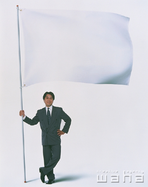 イラスト＆写真のストックフォトwaha（ワーハ）　人物、日本人、合成、メッセージボード、ビジネス、ビジネスマン、男性、白バック、屋外、正面、全身、白バック、紹介する、注目、大きい旗、なびく、はためく、翻る、真面目、仕事、働く、サラリーマン　p2-2162b