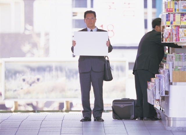 イラスト＆写真のストックフォトwaha（ワーハ）　人物、日本人、男性、40代、50代、ビジネス、ビジネスマン、1人、屋外、駅、ホーム、立つ、メッセージボード、正面、全身、仕事、働く、サラリーマン　p3-0259b