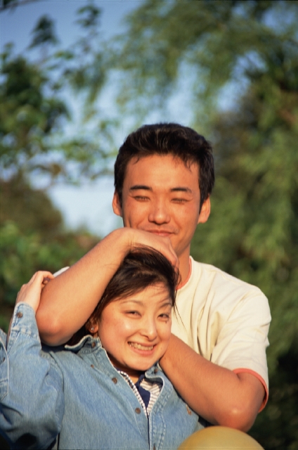 イラスト＆写真のストックフォトwaha（ワーハ）　人物、日本人、夫婦、カップル、男性、女性、20代、30代、2人、屋外、公園、コミュニケーション、抱く、笑顔、正面、上半身、笑う、笑い、スマイル　p3-0325bv