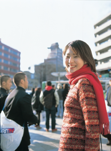 イラスト＆写真のストックフォトwaha（ワーハ）　人物、日本人、女性、20代、30代、1人、屋外、街、振り向く、上半身、笑顔、笑う、笑い、スマイル、街並み、街並　p3-0396a