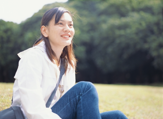 イラスト＆写真のストックフォトwaha（ワーハ）　人物、日本人、女性、20代、30代、1人、屋外、公園、森、座る、上半身、笑顔、笑う、笑い、スマイル　p3-0417bv