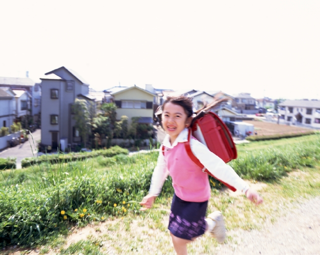 イラスト＆写真のストックフォトwaha（ワーハ）　人物、日本人、子供、小学生、女の子、1人、屋外、川、土手、通学、走る、ランドセル、上半身、ブレ　p3-0845bv