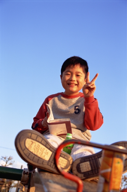 イラスト＆写真のストックフォトwaha（ワーハ）　人物、日本人、子供、小学生、男の子、1人、屋外、公園、ポーズ、上半身、本、青空　p3-0925bv