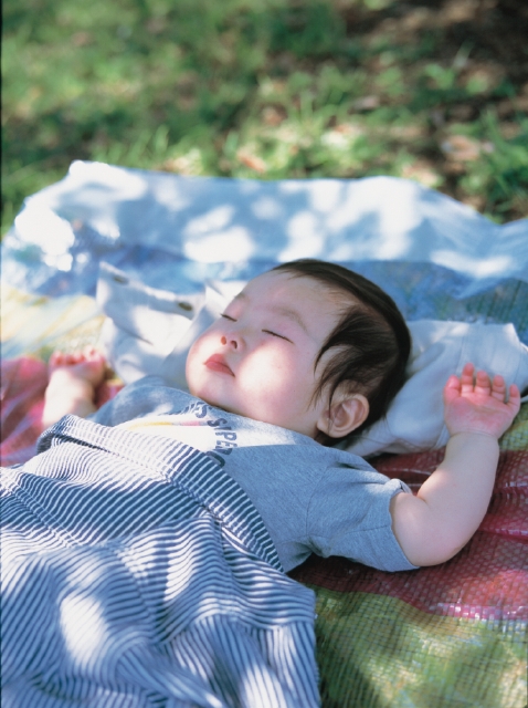 イラスト＆写真のストックフォトwaha（ワーハ）　人物、日本人、赤ちゃん、女の子、1人、屋外、草原、寝る、上半身　p3-0966b