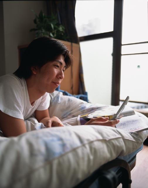 イラスト＆写真のストックフォトwaha（ワーハ）　人物、日本人、若者、10代、20代、男性、1人、屋内、部屋、ベット、携帯電話、若者1人暮らし、上半身　p3-1327bv