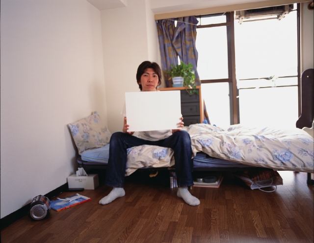 イラスト＆写真のストックフォトwaha（ワーハ）　人物、日本人、若者、10代、20代、男性、1人、屋内、部屋、ベット、座る、若者1人暮らし、全身、メッセージボード　p3-1331bv