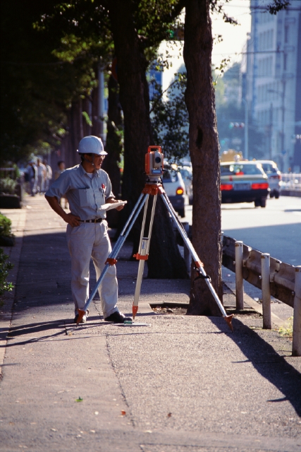 イラスト＆写真のストックフォトwaha（ワーハ）　人物、日本人、40代、50代、男性、職業、作業員、1人、屋外、街、働く、全身、ヘルメット、仕事、街並み、街並　p3-1446b