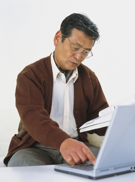 イラスト＆写真のストックフォトwaha（ワーハ）　人物、日本人、中高年、パソコン、白バック、男性、屋内、正面、上半身、スタジオ、白バック、父、メガネ、本、読む、座る、好奇心、興味、真剣　p4-0478a