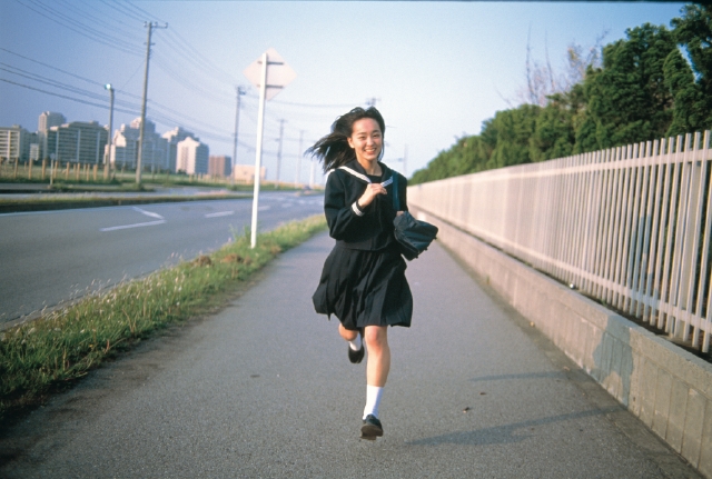 イラスト＆写真のストックフォトwaha（ワーハ）　人物、日本人、高校生、学生、走る、屋外、正面、全身、ポートレート、女の子、朝、出発、町角、道路、通り、町並、町並み、女子高生、セーラー服　p4-0746b