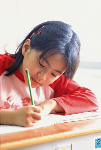 イラスト＆写真のストックフォトwaha（ワーハ）　人物、日本人、小学生、学生、夢、考える、屋内、正面、上半身、顔、アップ、授業、教室、机、座席、一生懸命、頑張る、努力、真剣、真面目、挑戦、鉛筆、ノート、書く　p4-0861b