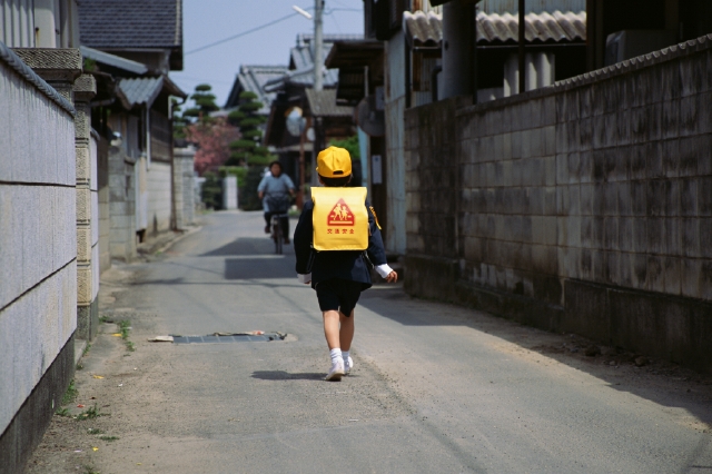 イラスト＆写真のストックフォトwaha（ワーハ）　人物、日本人、小学生、学生、歩く、屋外、後ろ姿、全身、一年生、ランドセル、制服、ブレザー、登校、登下校、通学、朝、住宅街、家並み、町角、出発、後姿、後ろ姿、うしろ姿、背中、町並、町並み　p4-0894b