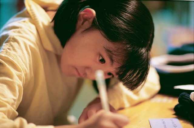 イラスト＆写真のストックフォトwaha（ワーハ）　人物、日本人、子供、頑張る、小学生、学生、屋内、横向き、横顔、上半身、書く、見つめる、宿題、机、鉛筆、子供部屋、子ども、こども　p4-1048b