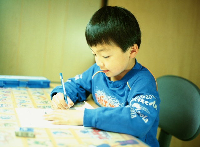 イラスト＆写真のストックフォトwaha（ワーハ）　人物、日本人、子供、頑張る、小学生、学生、屋内、横向き、横顔、上半身、書く、宿題、机、鉛筆、子供部屋、子ども、こども　p4-1049b