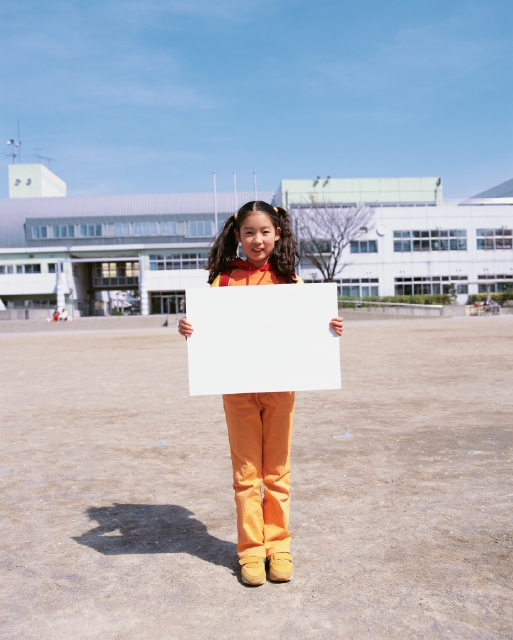 イラスト＆写真のストックフォトwaha（ワーハ）　人物、日本人、メッセージボード、小学生、学生、屋外、正面、全身、ポートレート、校庭、校内、青空、登校、登下校、通学　p4-1767b