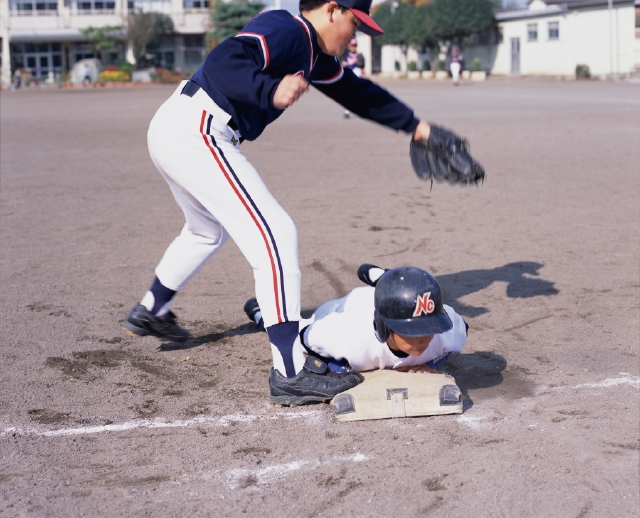 イラスト＆写真のストックフォトwaha（ワーハ）　人物、日本人、スポーツ、子供、屋外、横向き、横顔、全身、ベース、野球、ユニフォーム、グラウンド、校庭、滑り込む、グローブ、ヘルメット、試合、ゲーム、土、間に合う、セーフ、タッチ、うつぶせ、腹這い、勝負、運動、子ども、こども　p5-0149b