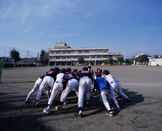 イラスト＆写真のストックフォトwaha（ワーハ）　人物、日本人、子供、屋外、後ろ姿、後姿、背中、全身、友達、グループ、仲間、集合、チームメイト、野球、ユニフォーム、青空、校庭、グラウンド、円陣、腰をおとす、後姿、後ろ姿、うしろ姿、背中、子ども、こども　p5-0187b