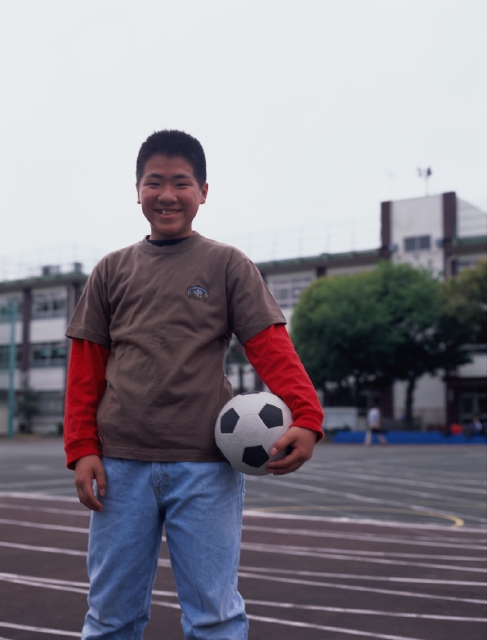 イラスト＆写真のストックフォトwaha（ワーハ）　人物、日本人、スポーツ、小学生、学生、子供、屋外、正面、上半身、ポートレート、サッカーボール、校庭、グラウンド、空、運動、子ども、こども　p5-0367b