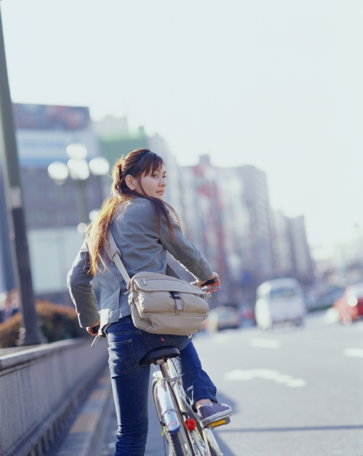 イラスト＆写真のストックフォトwaha（ワーハ）　人物、日本人、自転車、街、若者、屋外、後ろ姿、横顔、上半身、女の子、女性、見つめる、道路、朝、振り向く、通学、後姿、後ろ姿、うしろ姿、背中、街並み、街並　p6-0507bv