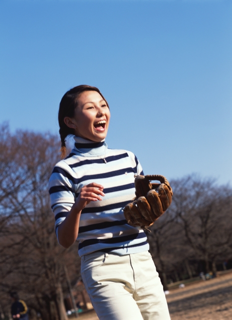 イラスト＆写真のストックフォトwaha（ワーハ）　人物、日本人、若者、公園、スポーツ、元気、健康、屋外、横向き、横顔、上半身、女の子、女性、広場、草原、笑う、嬉しい、楽しい、はしゃぐ、キャッチボール、グローブ、青空、遊ぶ、あそぶ、あそび、遊ぶ、遊び、笑う、笑い、スマイル、運動　p6-0933bv