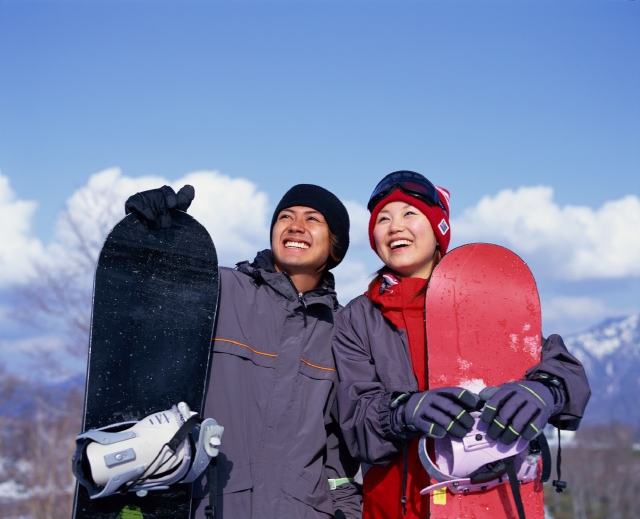 イラスト＆写真のストックフォトwaha（ワーハ）　人物、日本人、冬、カップル、若者、スポーツ、屋外、正面、上半身、ポートレート、2人、男の子、男性、女の子、女性、スノーボード、スノボー、グローブ、手袋、ゴーグル、レジャー、リゾート、山、アウトドア、青空、運動、季節、四季、ゆき、雪　p6-1295b