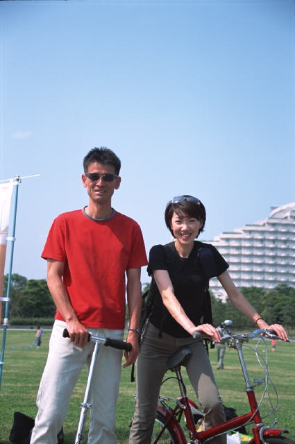 イラスト＆写真のストックフォトwaha（ワーハ）　人物、日本人、夫婦、自転車、屋外、正面、上半身、ポートレート、2人、キックボード、サングラス、メガネ、公園、広場、草原、青空、元気　p8-0166b-data