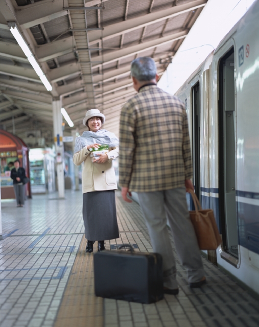 イラスト＆写真のストックフォトwaha（ワーハ）　人物、日本人、夫婦、旅行、中高年、屋外、後ろ姿、正面、全身、2人、男性、女性、フルムーン旅行、出発、旅行鞄、トランク、駅、新幹線、乗り物、電車、駅弁、後姿、後ろ姿、うしろ姿、背中　p8-1359b