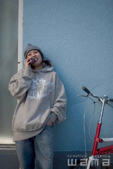 イラスト＆写真のストックフォトwaha（ワーハ）　人物、日本人、若者、自転車、街、携帯電話、話す、コミュニケーション、街並み、街並　pcx-0316b