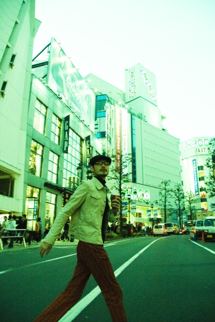 イラスト＆写真のストックフォトwaha（ワーハ）　人物、日本人、男性、20代、30代、1人、屋外、街、上半身、飲み物、メガネ、歩く、横向き、街、街並、街並み、ビル、ビルディング　w1-2357bv