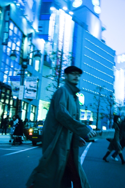 イラスト＆写真のストックフォトwaha（ワーハ）　人物、日本人、男性、20代、30代、1人、屋外、街、上半身、メガネ、夜、ブレ、歩く、街、街並、街並み、夜、夜景　w1-2368bv
