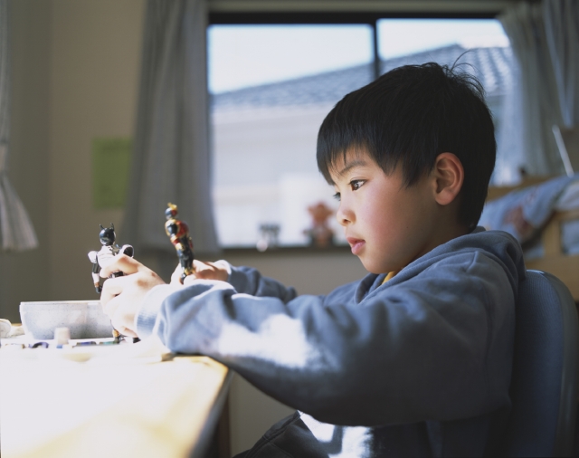 イラスト＆写真のストックフォトwaha（ワーハ）　人物、日本人、子供、男の子、1人、屋内、住宅、子供部屋、遊ぶ、机、おもちゃ、人形、真剣、上半身、横向き、あそぶ、遊ぶ、あそび、遊び　w1-4444bv