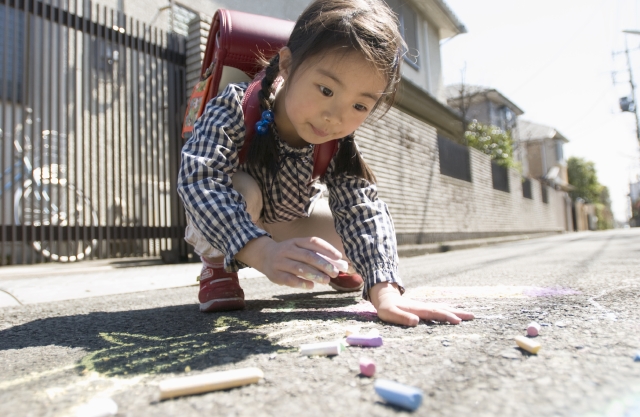 イラスト＆写真のストックフォトwaha（ワーハ）　人物、日本人、子供、学生、小学生、女の子、1人、屋外、町、住宅街、道路、通学、登校、下校、遊ぶ、真剣、絵を描く、ローアングル、あそぶ、遊ぶ、あそび、遊び、描く、絵、お絵かき、落書き、らくがき　w1-4682bv