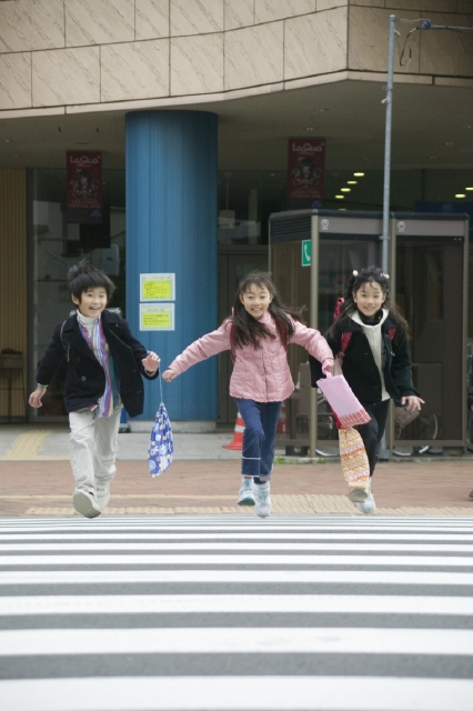 イラスト＆写真のストックフォトwaha（ワーハ）　人物、日本人、子供、学生、小学生、男の子、女の子、友達、グループ、3人、屋外、街、横断歩道、走る、通学、登校、下校、正面、全身、街、街並、街並み　w1-5239bv