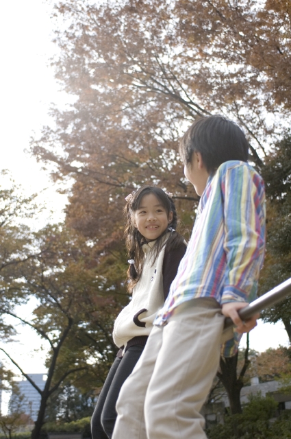 イラスト＆写真のストックフォトwaha（ワーハ）　人物、日本人、子供、男の子、女の子、2人、屋外、公園、学校、小学校、グラウンド、遊ぶ、鉄棒、全身、会話、ローアングル、あそぶ、遊ぶ、あそび、遊び　w1-5275bv