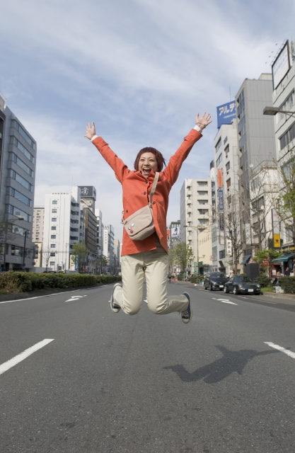イラスト＆写真のストックフォトwaha（ワーハ）　人物、日本人、女性、若者、10代、20代、1人、屋外、街、街並み、道路、ジャンプ、バンザイ、喜ぶ、全身、街、街並、街並み、はねる、跳ねる、とぶ　w1-7126bv