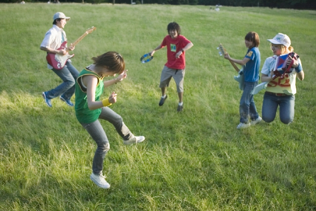 イラスト＆写真のストックフォトwaha（ワーハ）　人物、日本人、男性、女性、若者、10代、20代、グループ、屋外、草原、公園、趣味、楽器、ギター、音楽、バンド、ジャンプ、全身、集合、はねる、跳ねる、とぶ　w1-7249c