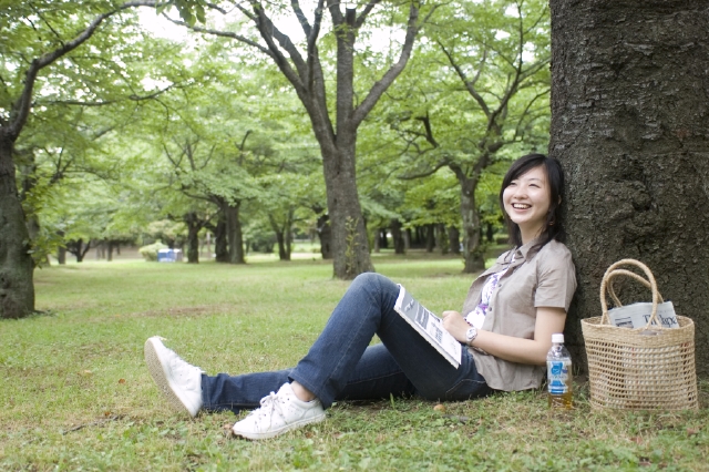 イラスト＆写真のストックフォトwaha（ワーハ）　人物、日本人、女性、若者、20代、30代、1人、屋外、公園、草原、緑、木、座る、笑顔、ポートレート、全身、笑顔、笑い、笑う、スマイル　w1-8326bv