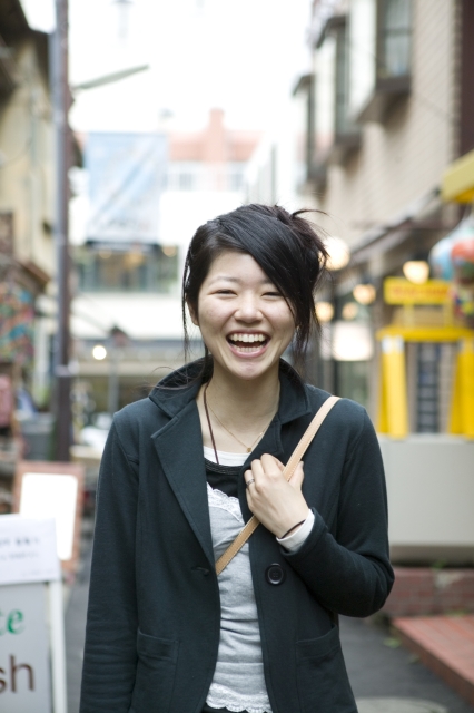 イラスト＆写真のストックフォトwaha（ワーハ）　人物、日本人、女性、若者、10代、20代、1人、屋外、街、笑顔、上半身、正面、ポートレート、街、街並み、街並、笑顔、笑い、笑う、スマイル　w2-2065bv