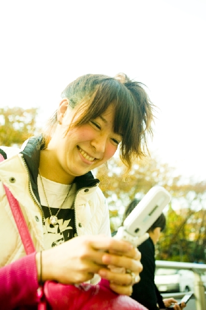 イラスト＆写真のストックフォトwaha（ワーハ）　人物、日本人、女性、若者、10代、20代、1人、屋外、街、携帯電話、笑顔、上半身、街、街並み、街並、笑顔、笑い、笑う、スマイル　w2-5109b