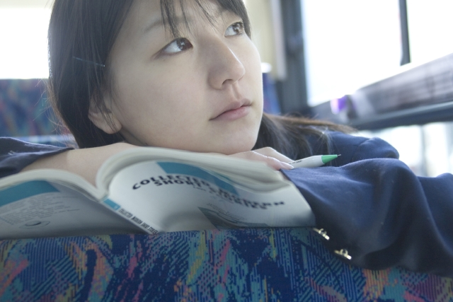 イラスト＆写真のストックフォトwaha（ワーハ）　人物、日本人、女性、学生、高校生、女子高生、10代、1人、屋内、乗り物、バス、車内、教科書、顔、アップ、車内、車内　w2-5612b