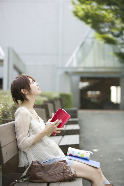 イラスト＆写真のストックフォトwaha（ワーハ）　人物、日本人、女性、若者、学生、大学生、10代、20代、1人、屋外、キャンパス、大学、座る、テキスト、横向き　w2-8086b